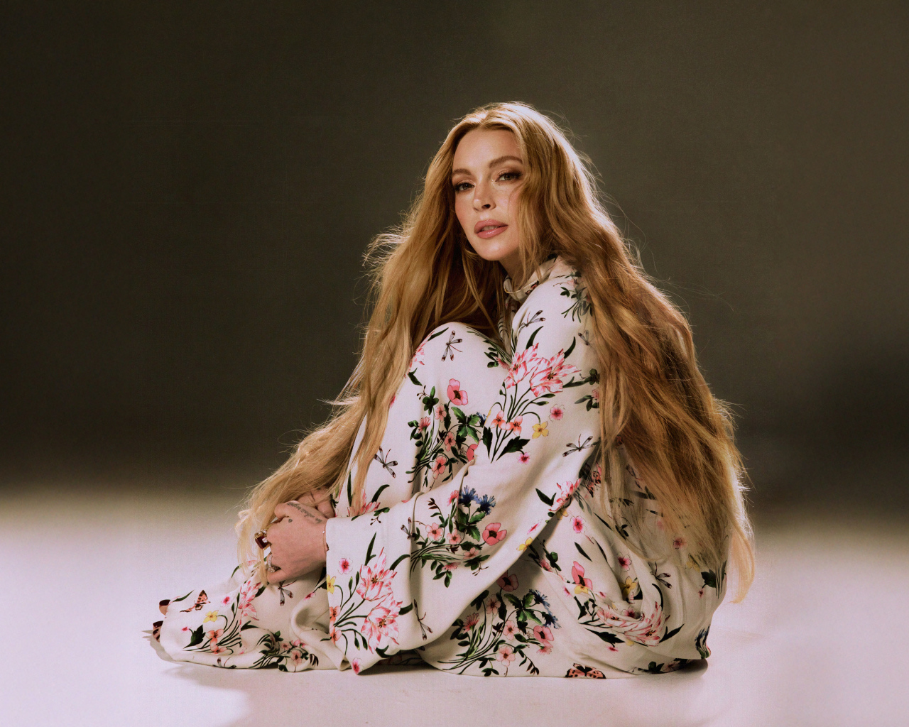 Популярная актриса Линдси Лохан в платье сидит на полу