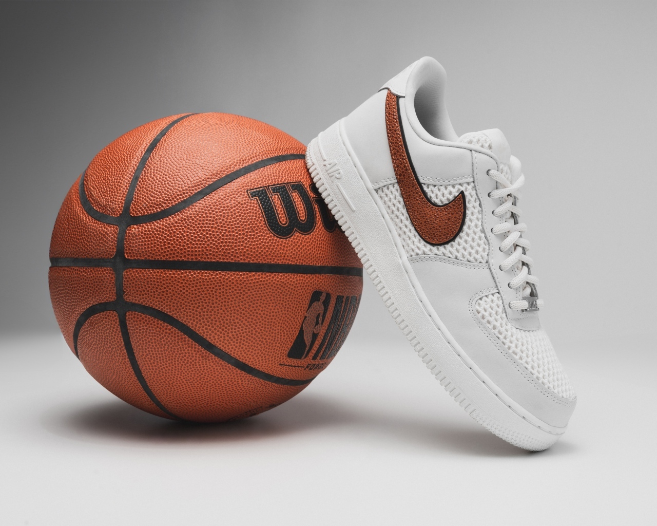 Спортивная обувь и баскетбольный мяч на сером фоне