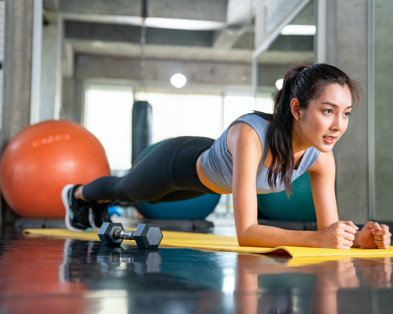 Спортивная девушка делает планку в спортзале