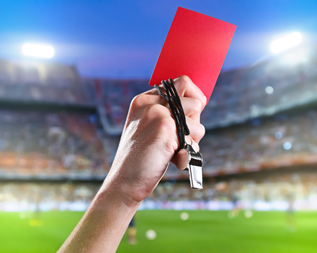Свисток тренера и красная карточка в руке