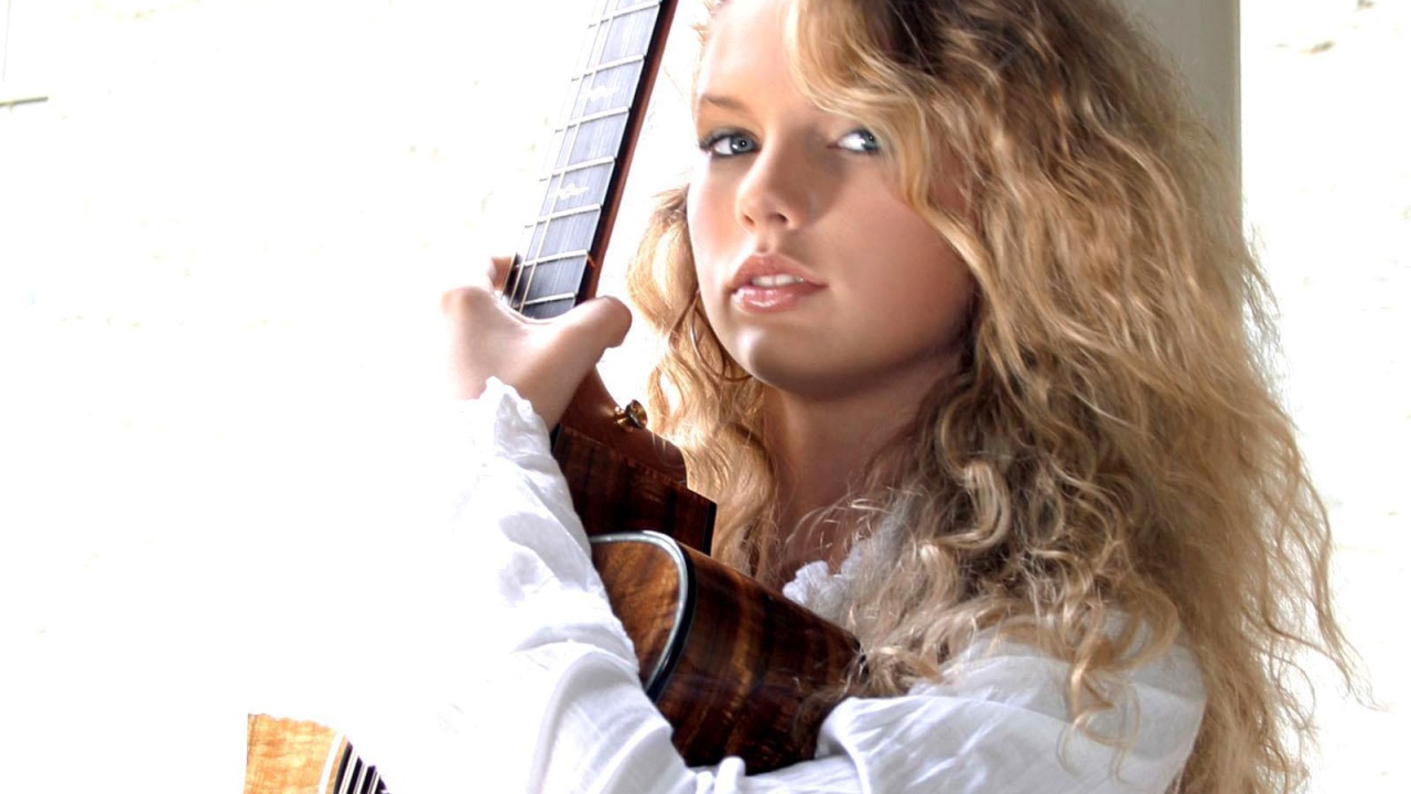 Taylor Swift обнимает свою гитару