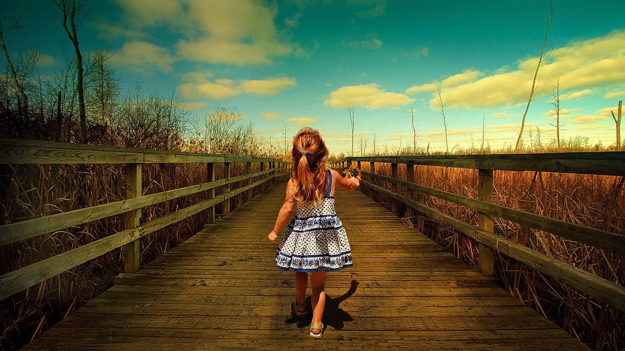 Девочка идет по деревянному мосту