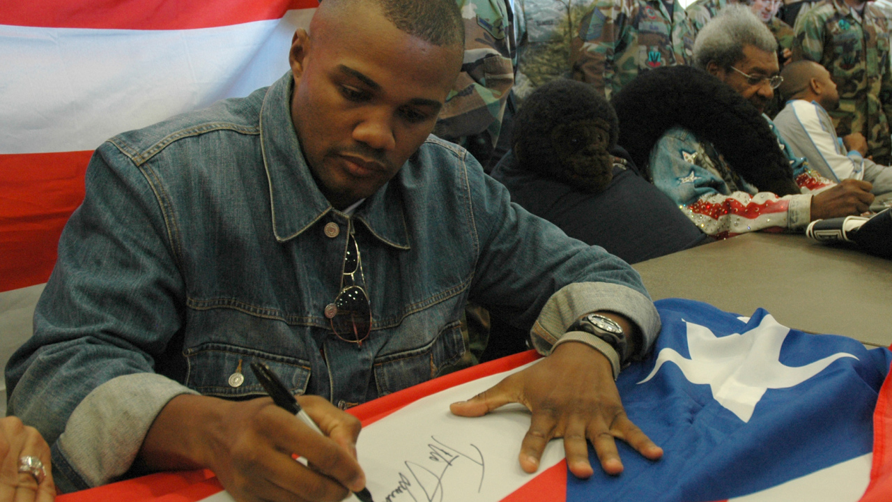 Боксер Феликс Тринидад подписывает флаг