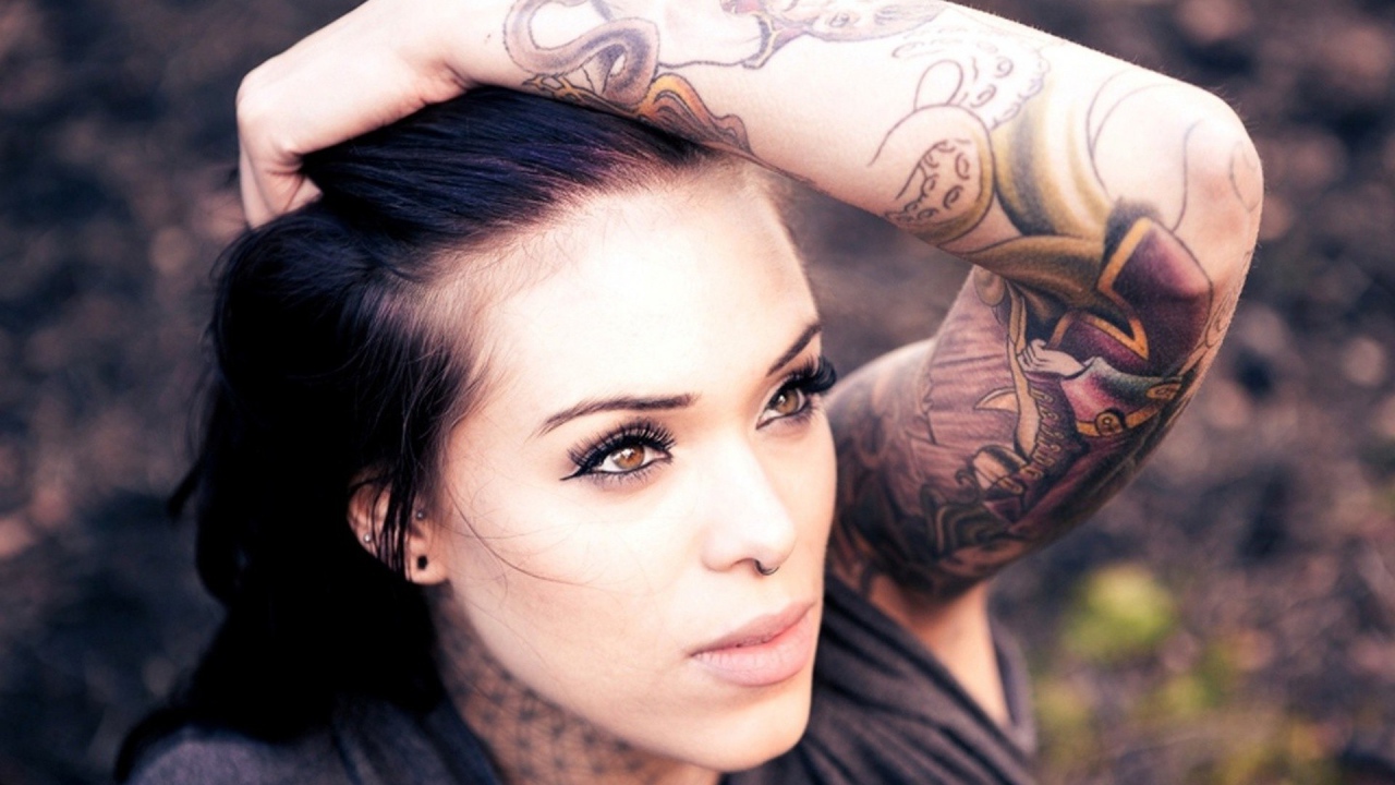 Девушка с цветной татуировкой на руке
