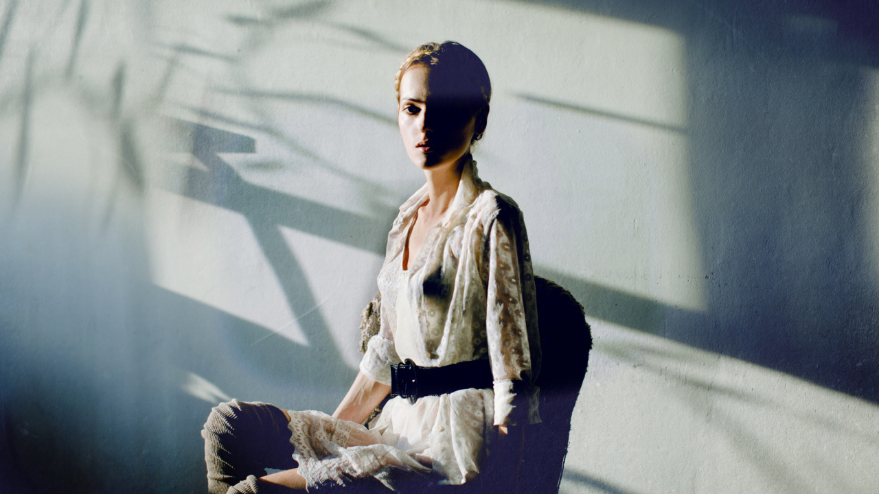 Фотография девушки на фоне белой стены