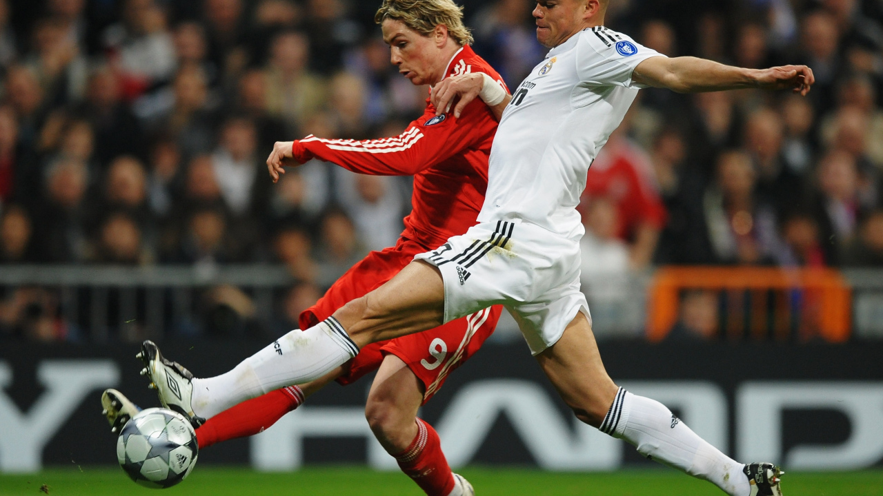 Игрок из Реал Мадрид Пепе пытается взять мяч