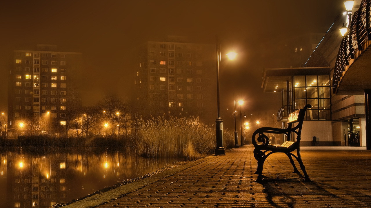 Скамейка около реки в городе