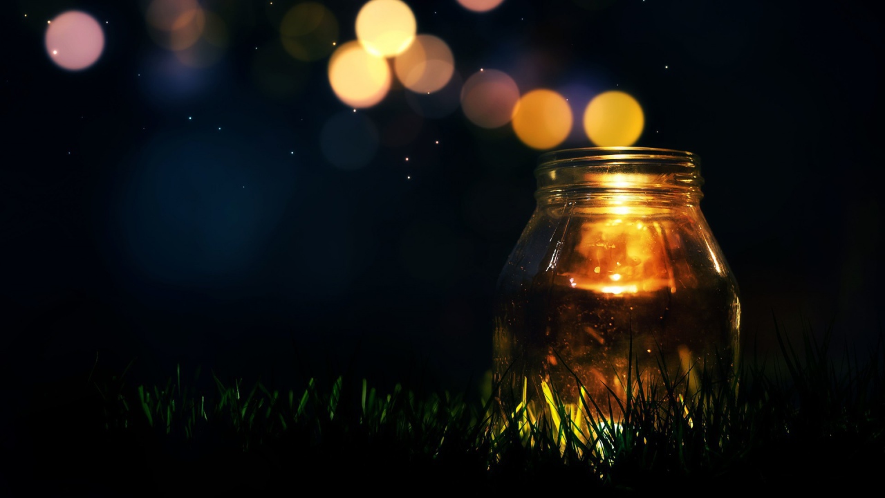 Glass jar on the grass at night