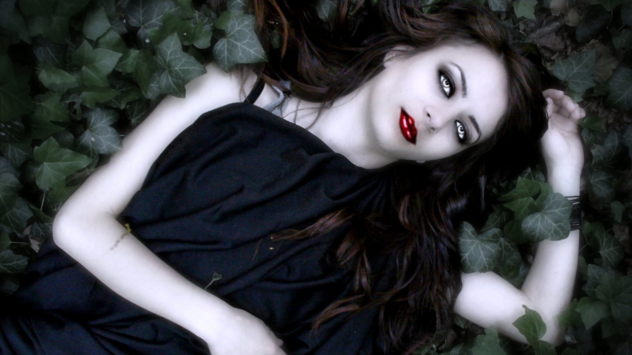 Девушка вампир лежит в листьях