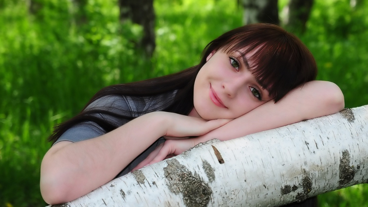 Девушка улыбается в лесу