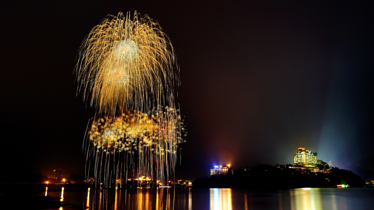 Праздничный фейерверк отражается в воде