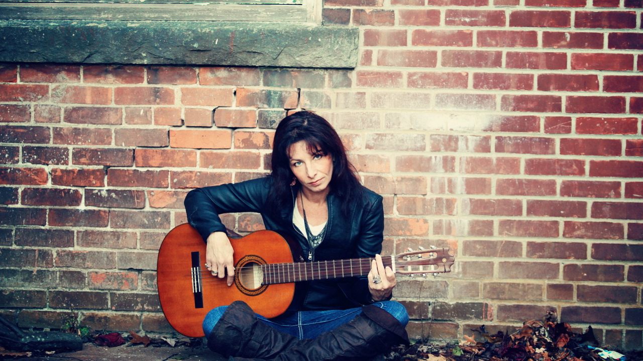 Девушка с гитарой у стены