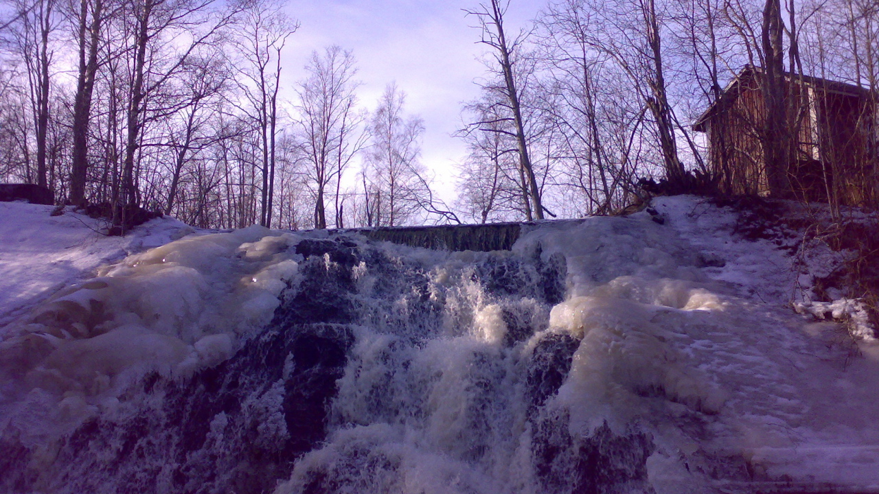 Замерзший водопад и хижина лесника