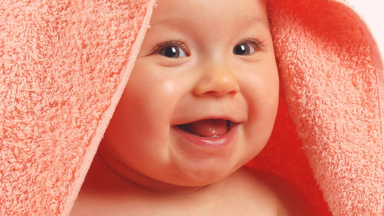 Ребенок в полотенце смеется