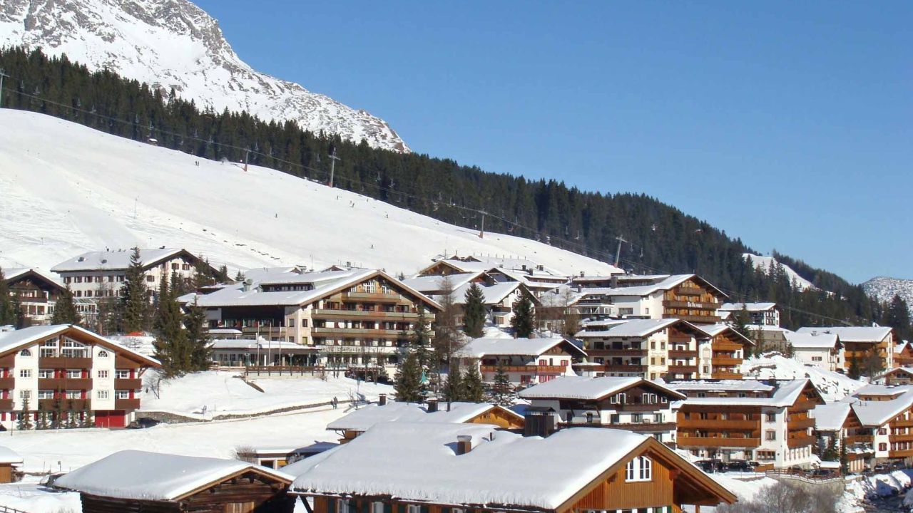 Дома на фоне гор на горнолыжном курорте Лех, Австрия