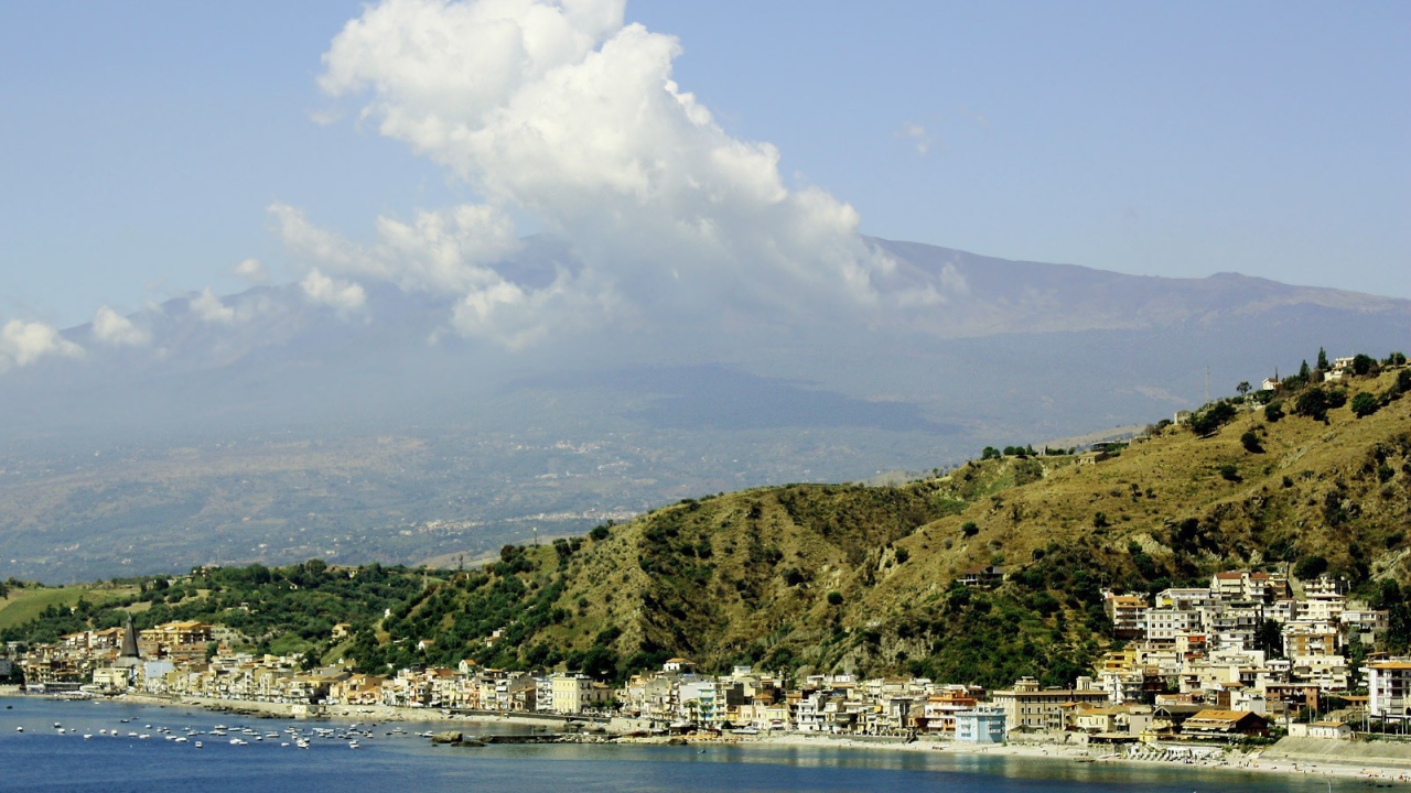 Город на фоне вулкана Этна, на острове Сицилия, Италия