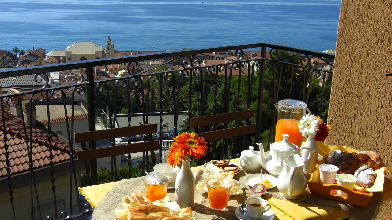 Отдых в кафе на террассе на курорте в Пьетра Лигуре, Италия