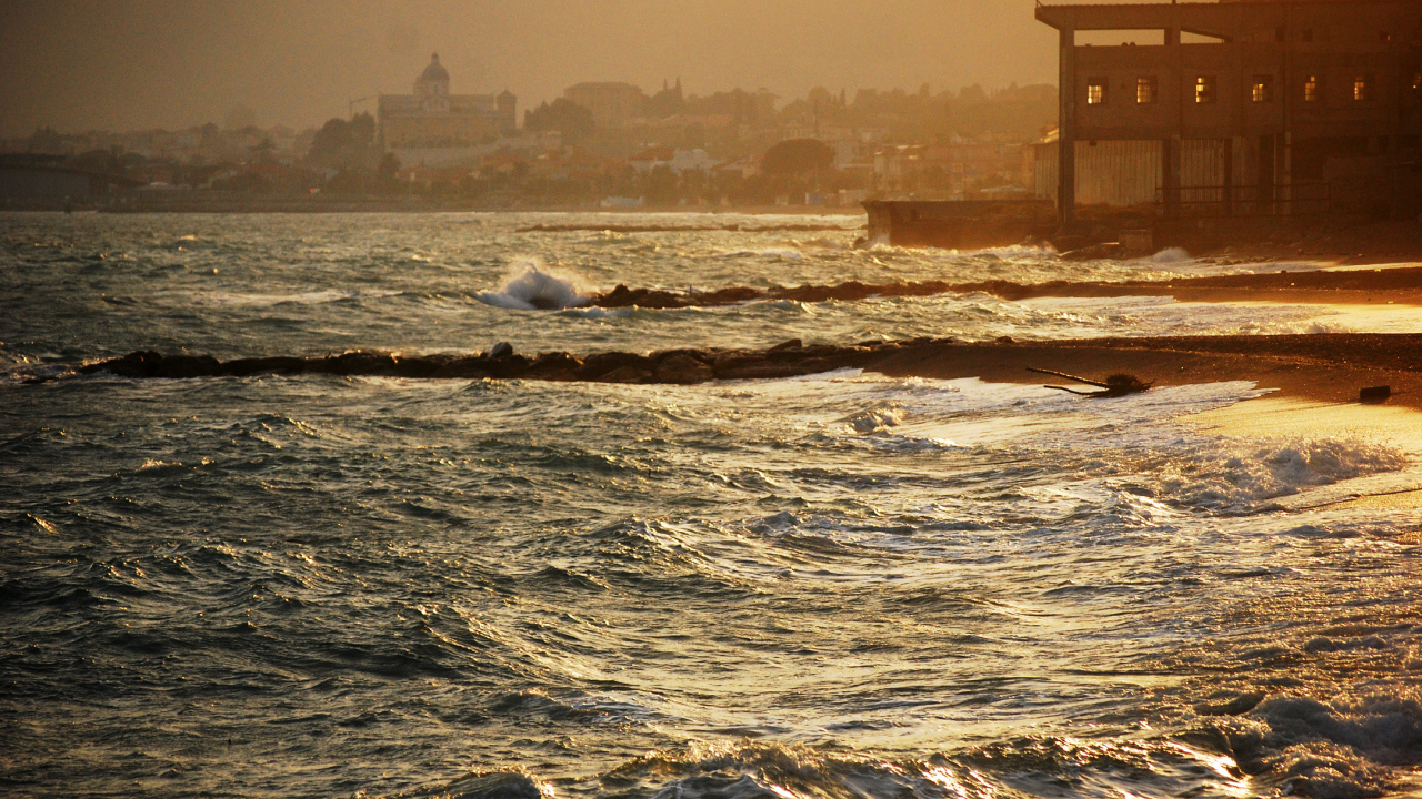 Закат на пляже на курорте в Пьетра Лигуре, Италия
