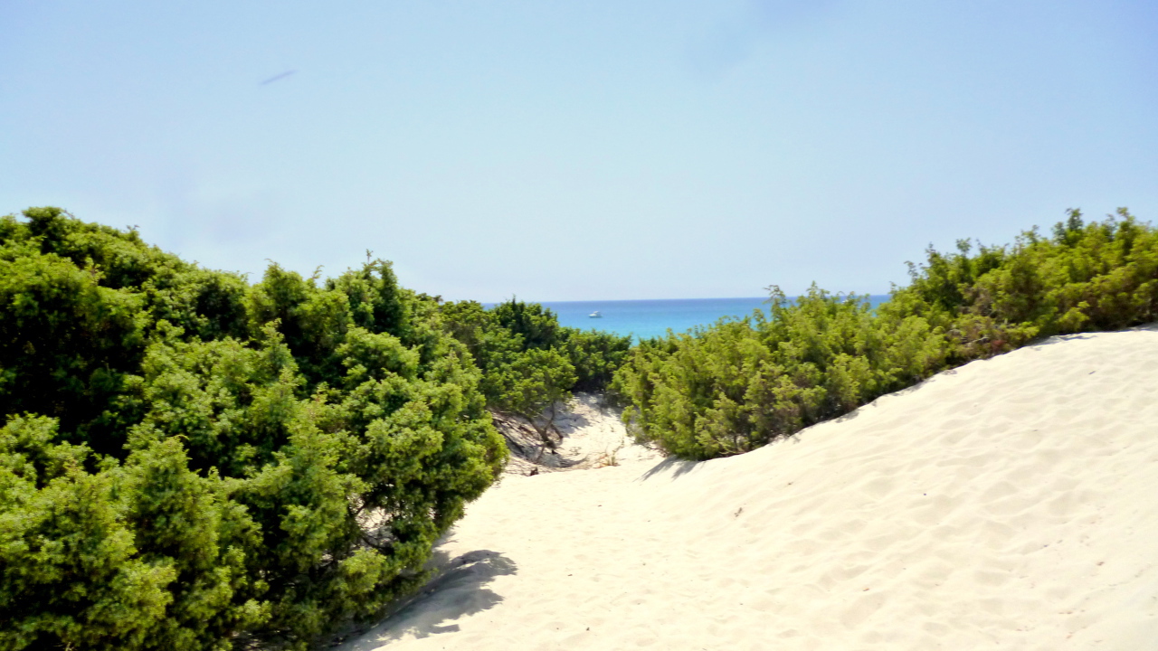 Белый песок на пляже на курорте Вилласимиус, Италия