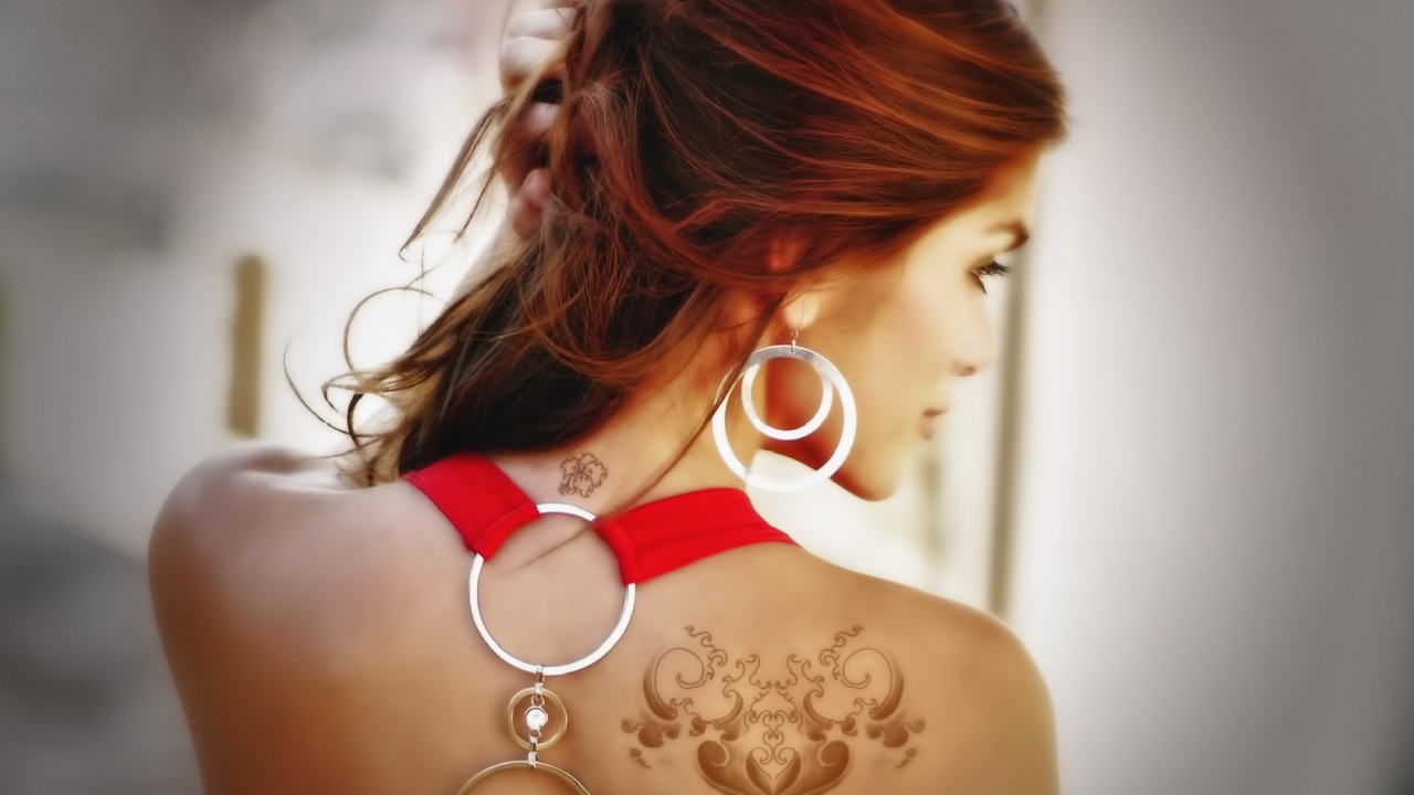Девушка с татуировками на плече и шее