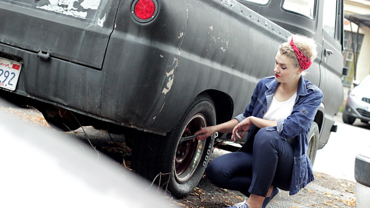 Девушка чинит автомобиль