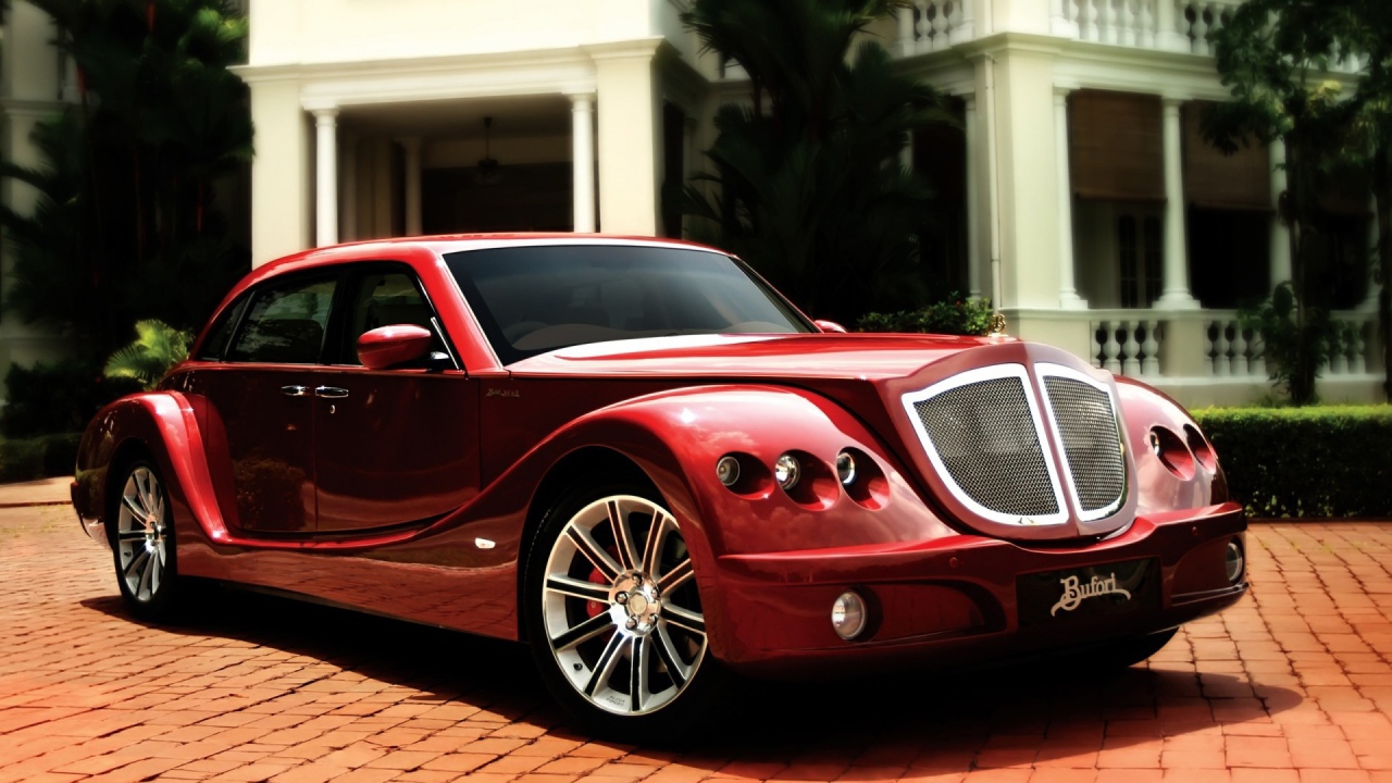 Красный роскошный автомобиль на мощеной дорожке