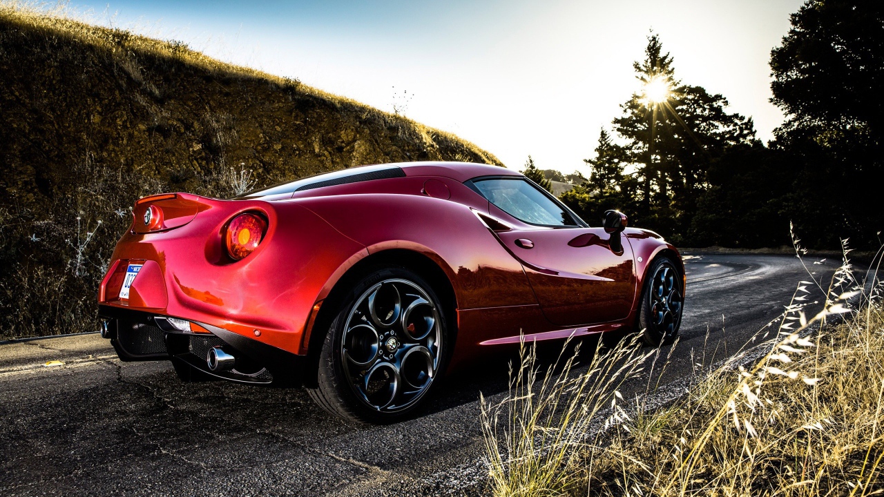 Красная Alfa Romeo 4C на повороте дороги