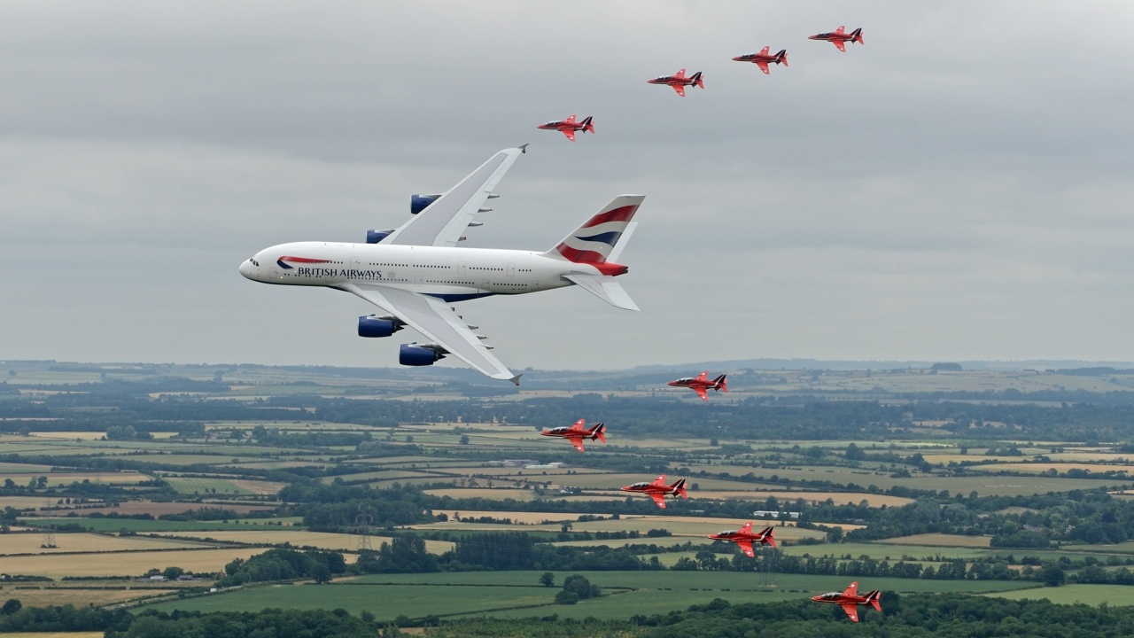 Airbus A380 в сопровождении красных истребителей