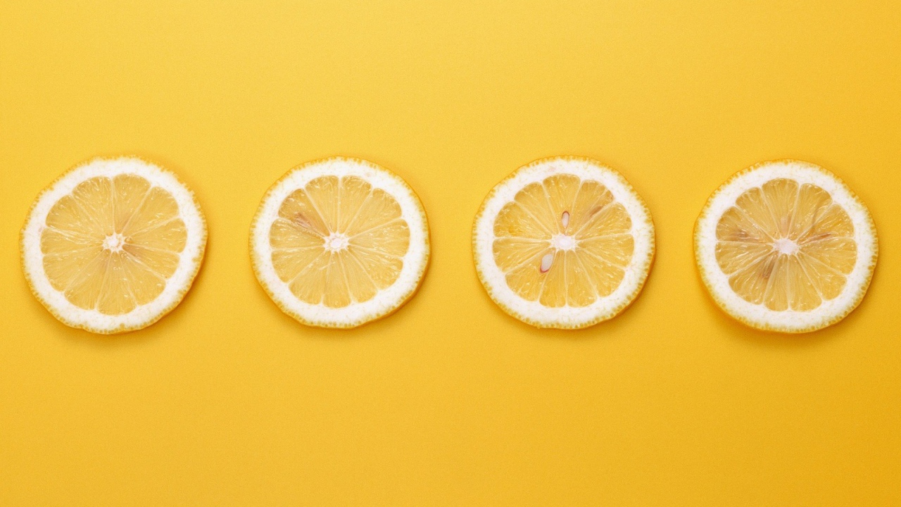 Кружки лимона, желтый фон