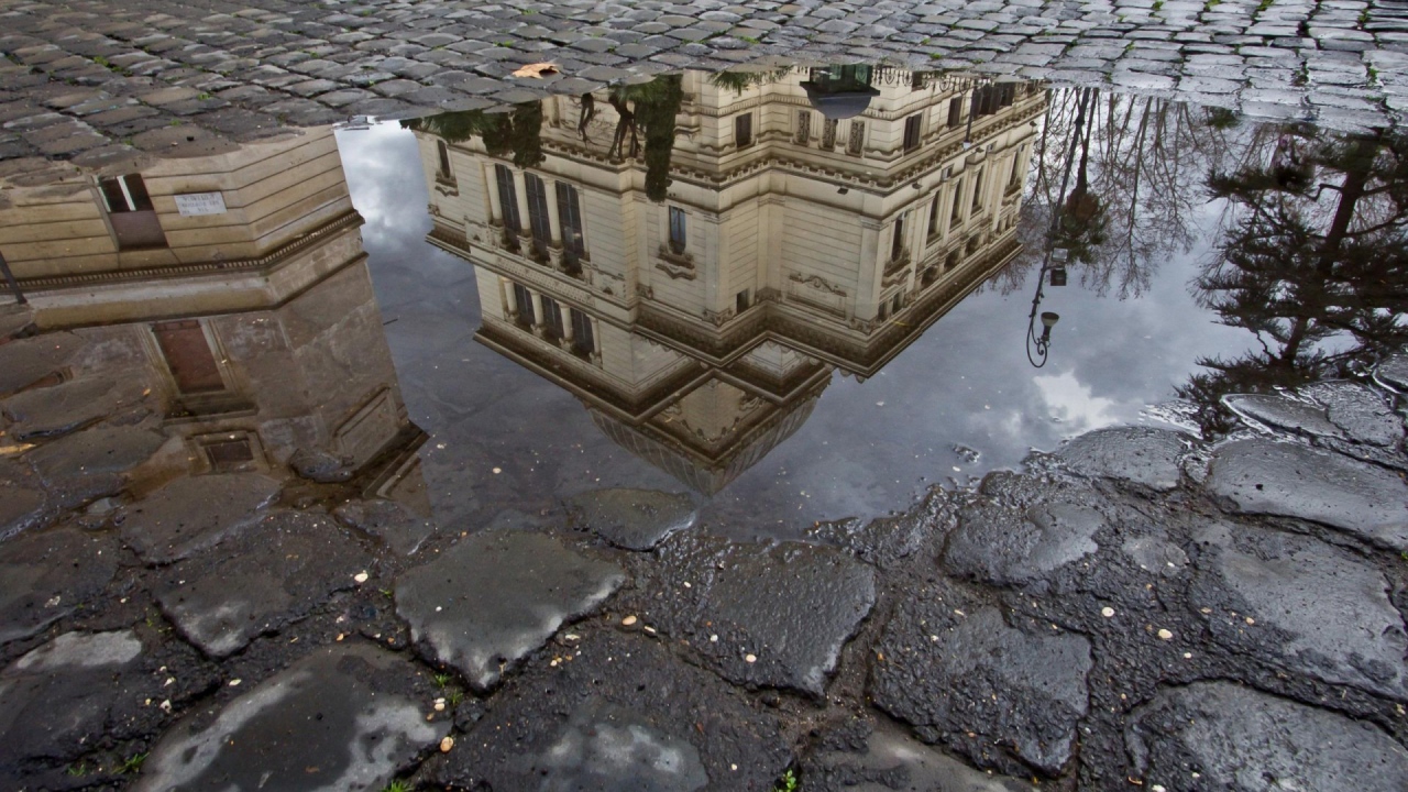 Отражение городского здания в луже