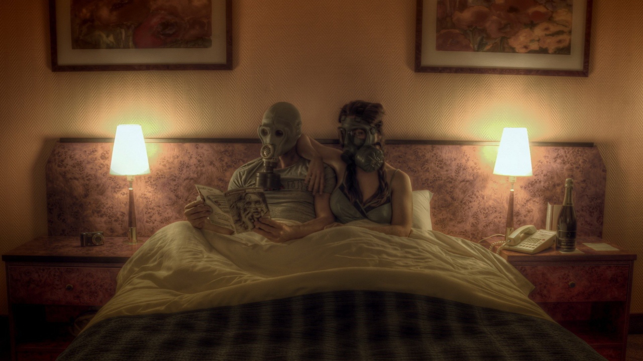 Семейная пара лежит в кровати в масках