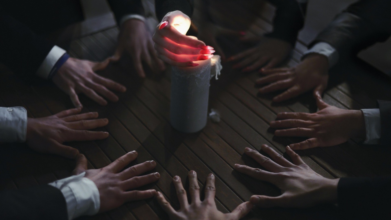 Люди вызывают духа при помощи свечи