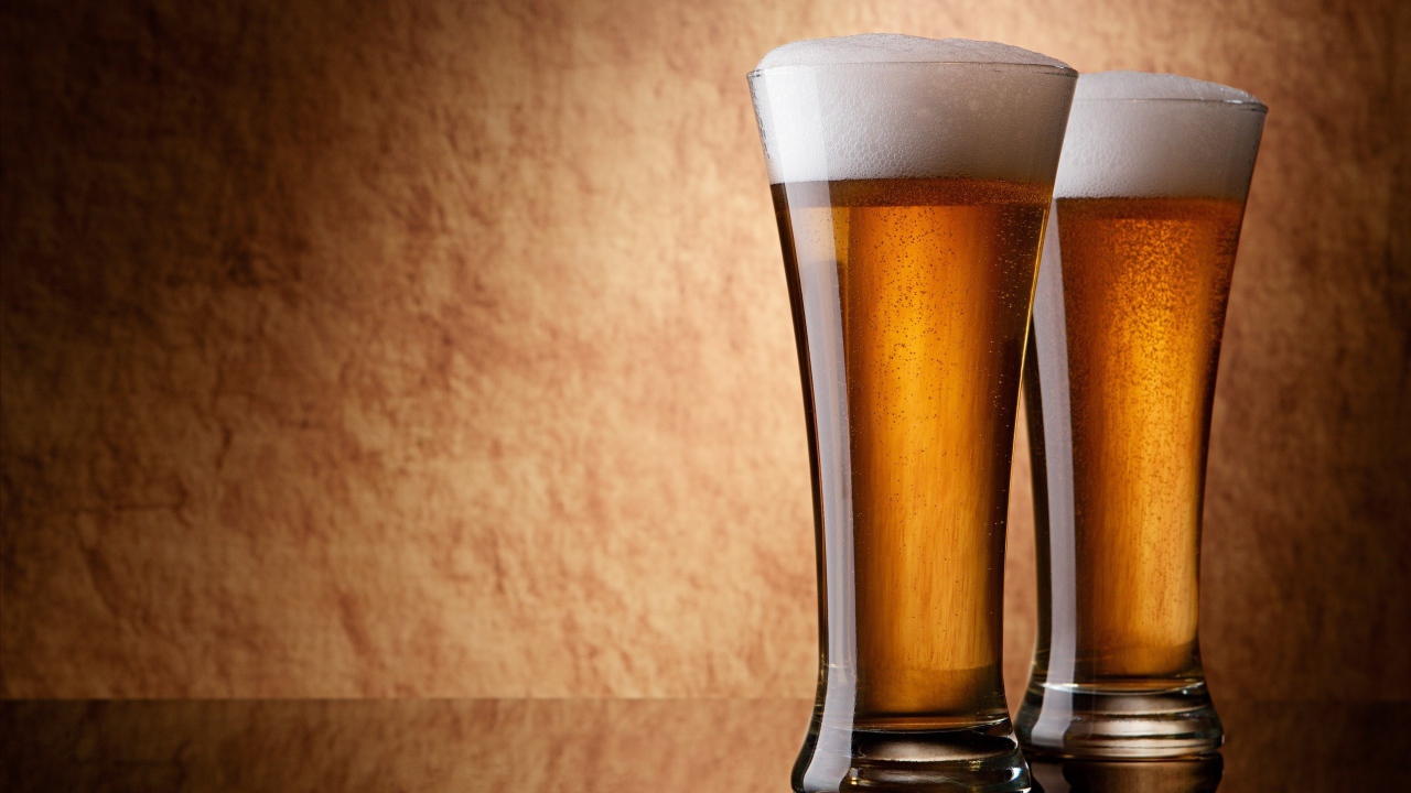Два бокала пива, коричневый фон