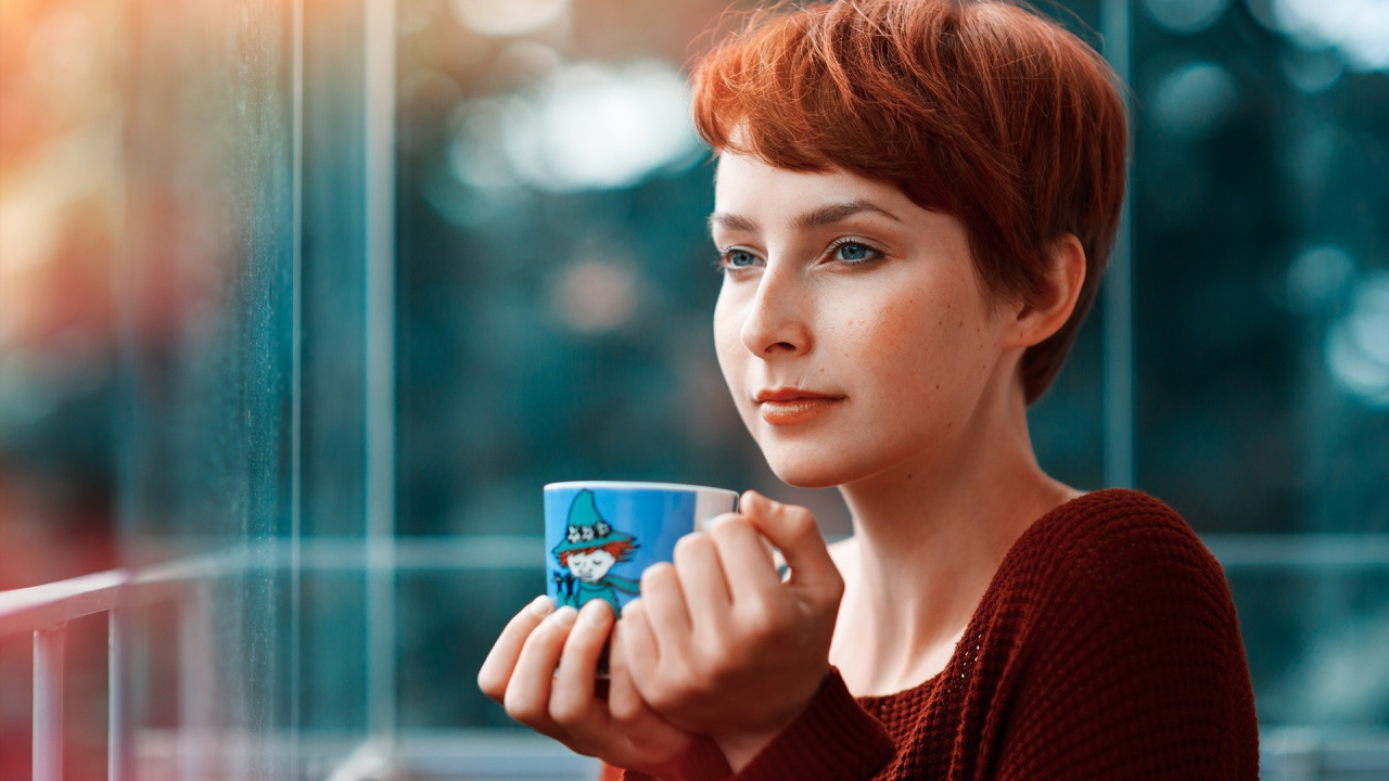 Девушка с короткими волосами пьет кофе