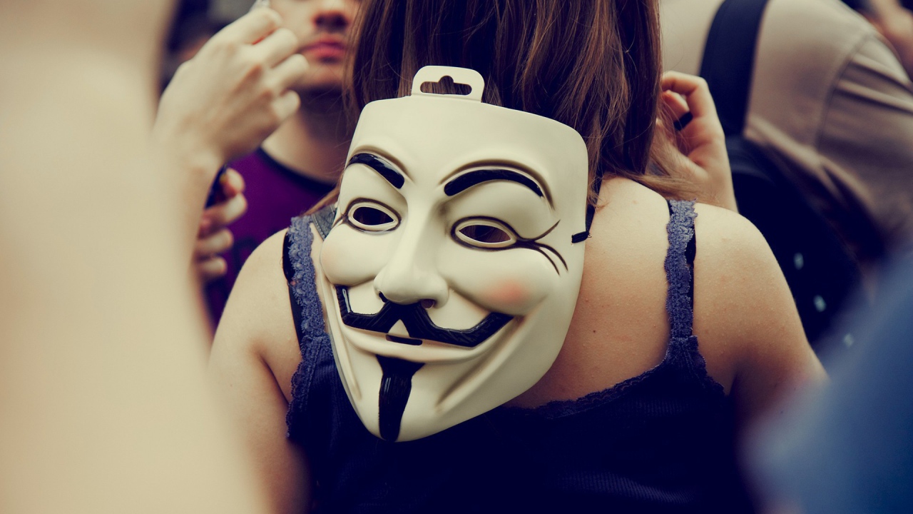 Маска Анонимуса на затылке девушки