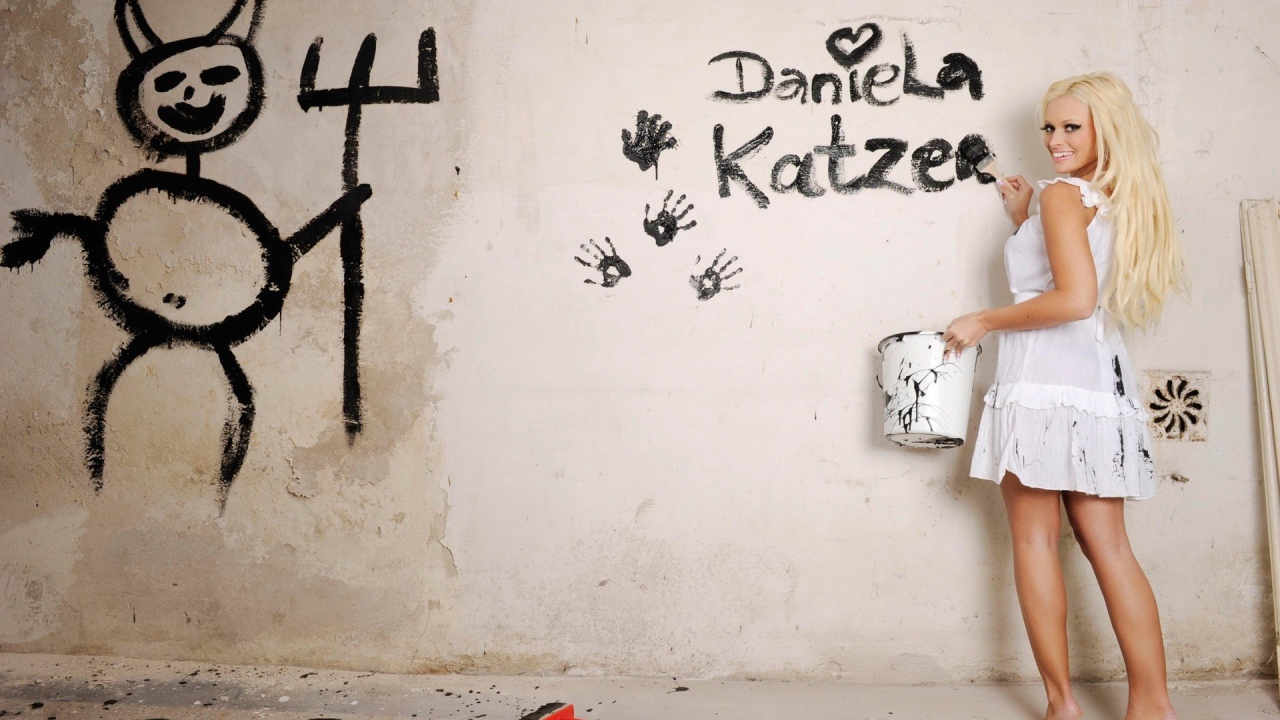 Блондинка рисует на стене