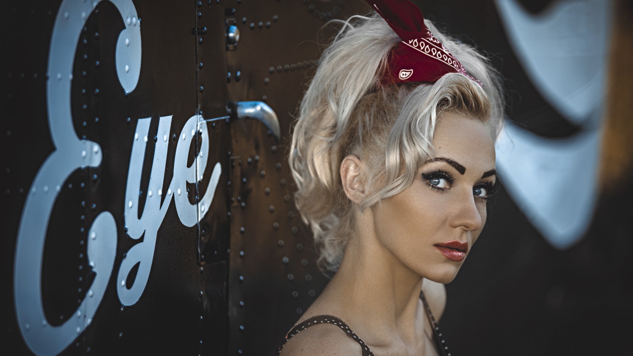 Блондинка с ретро прической у дверей гримерной