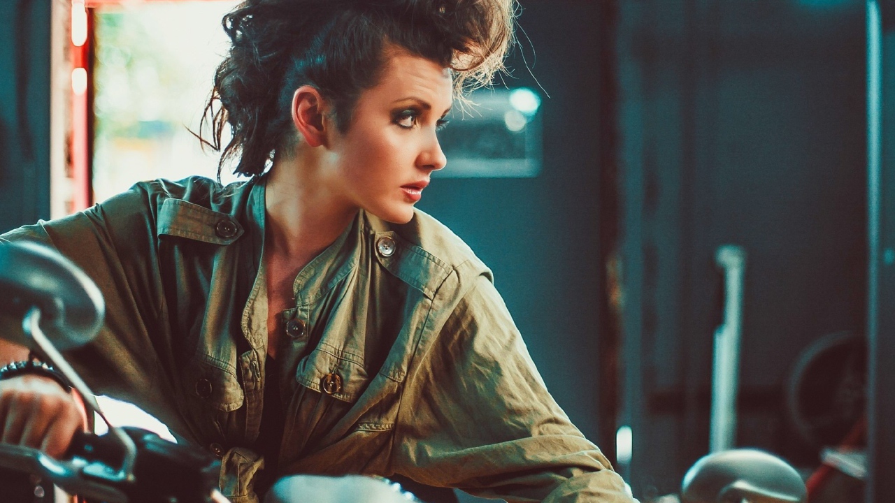 Брюнетка с высокой прической на мотоцикле