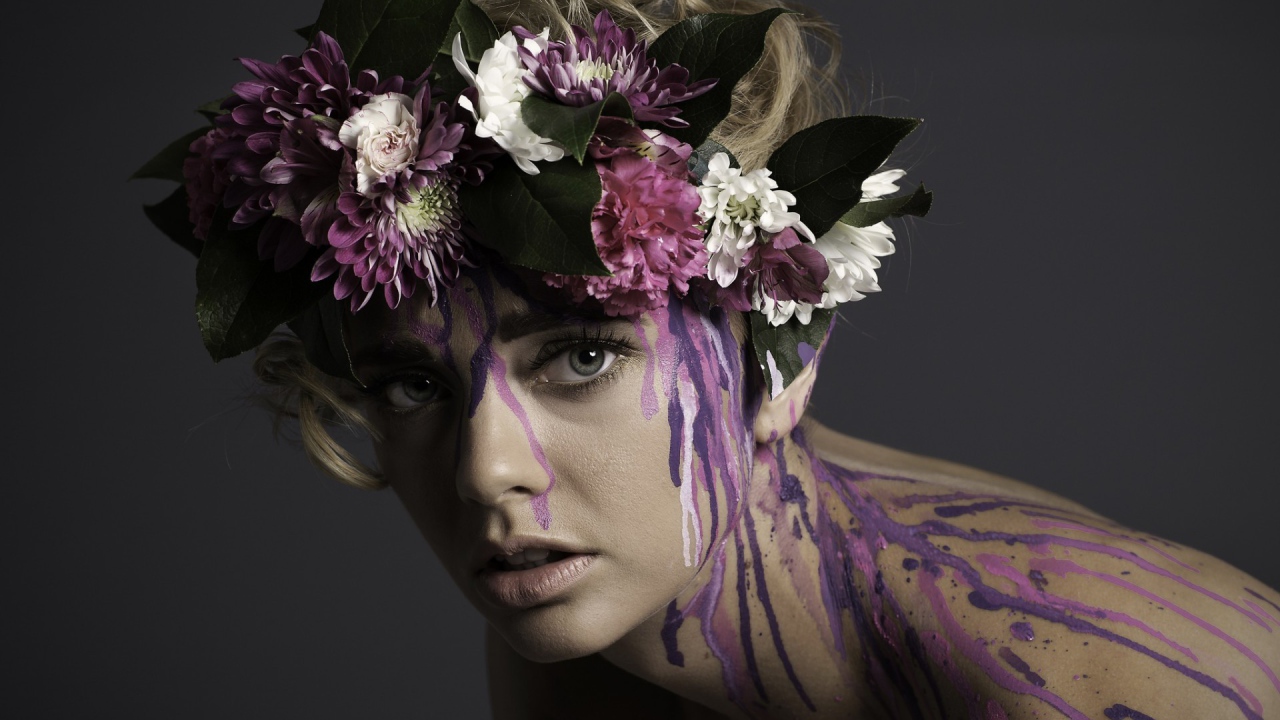 Цветочный венок на голове девушки и брызги краски по телу