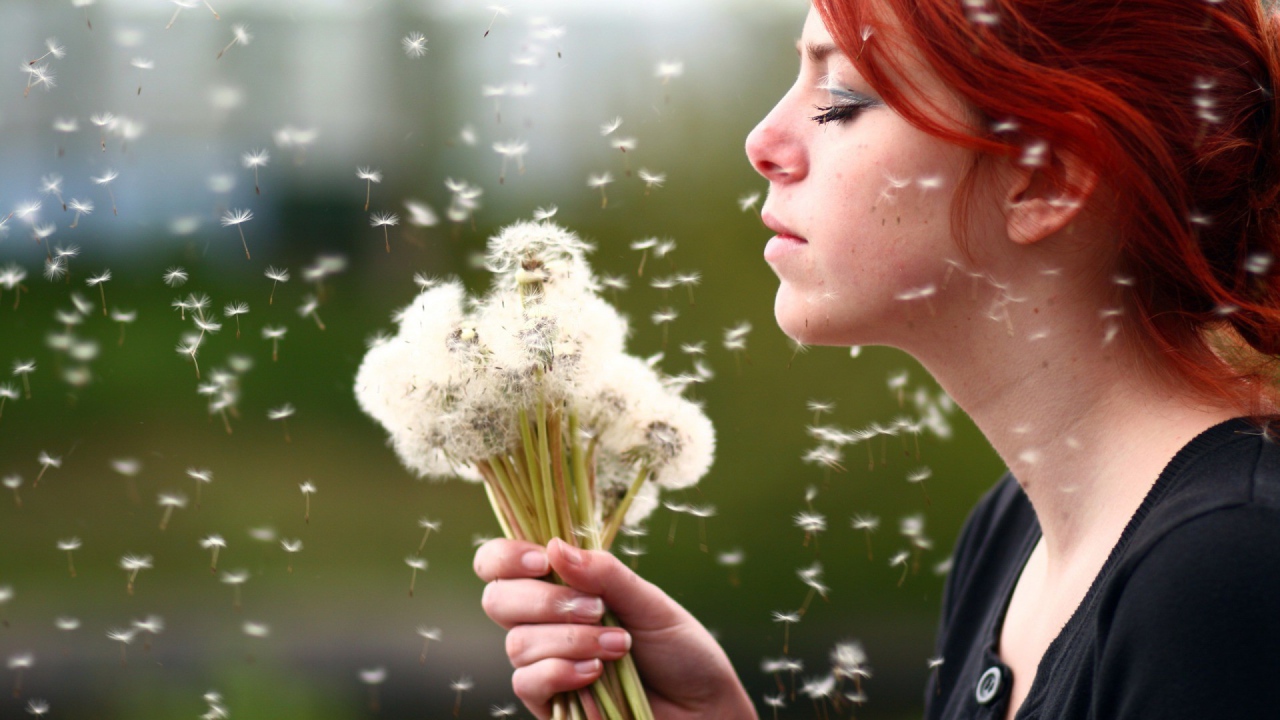 Девушка держит в руках букет одуванчиков