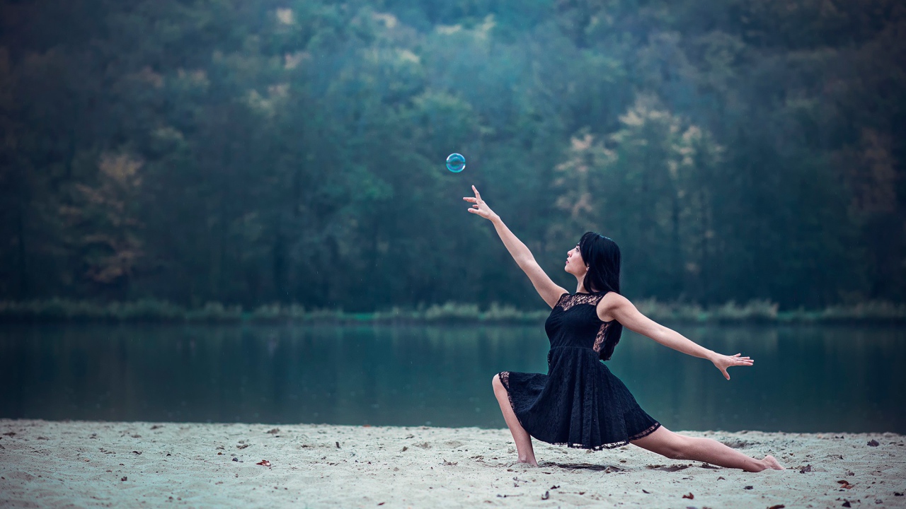 Девушка в черном платье и мыльный пузырь