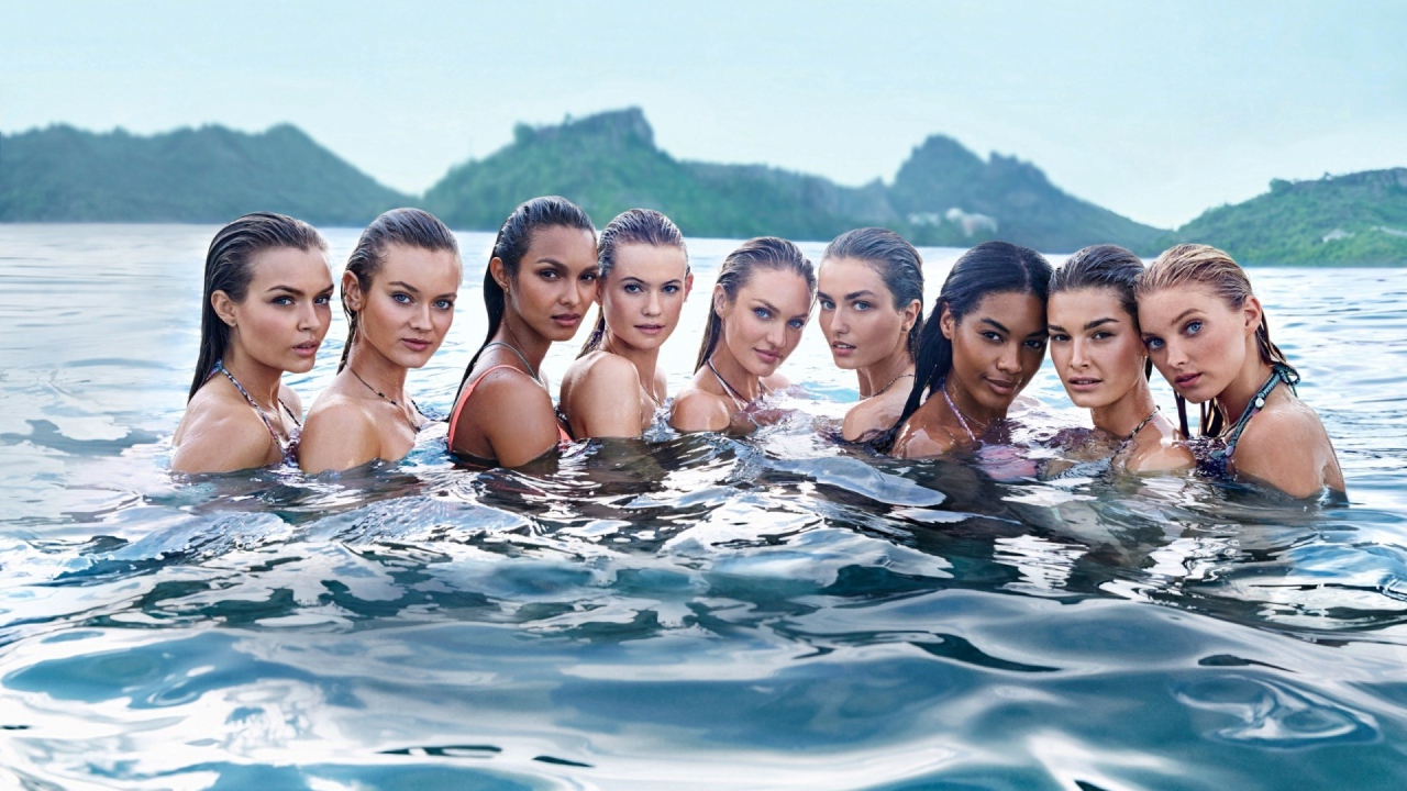 Девушки стоят в воде озера по плечи