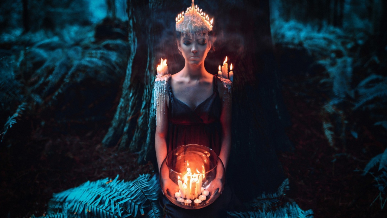 Девушка в окружении свечей в лесу