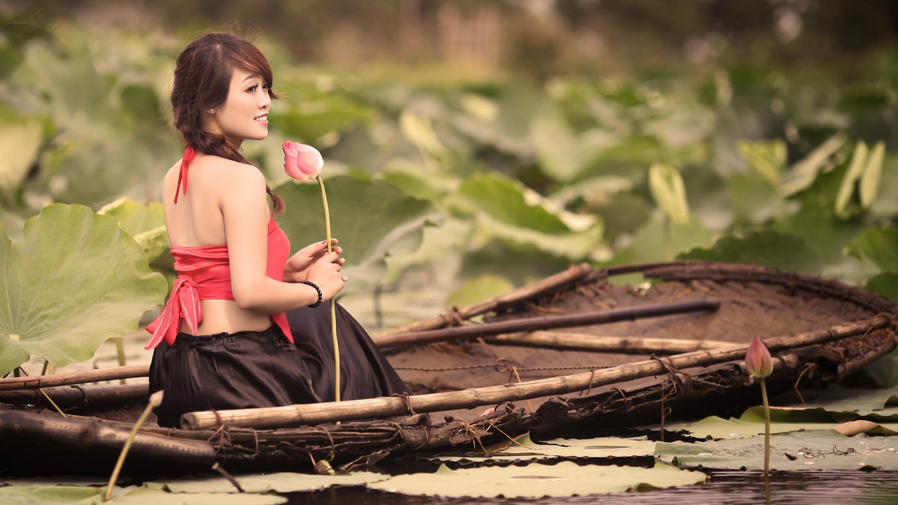 Девушка с цветком сидит в лодке