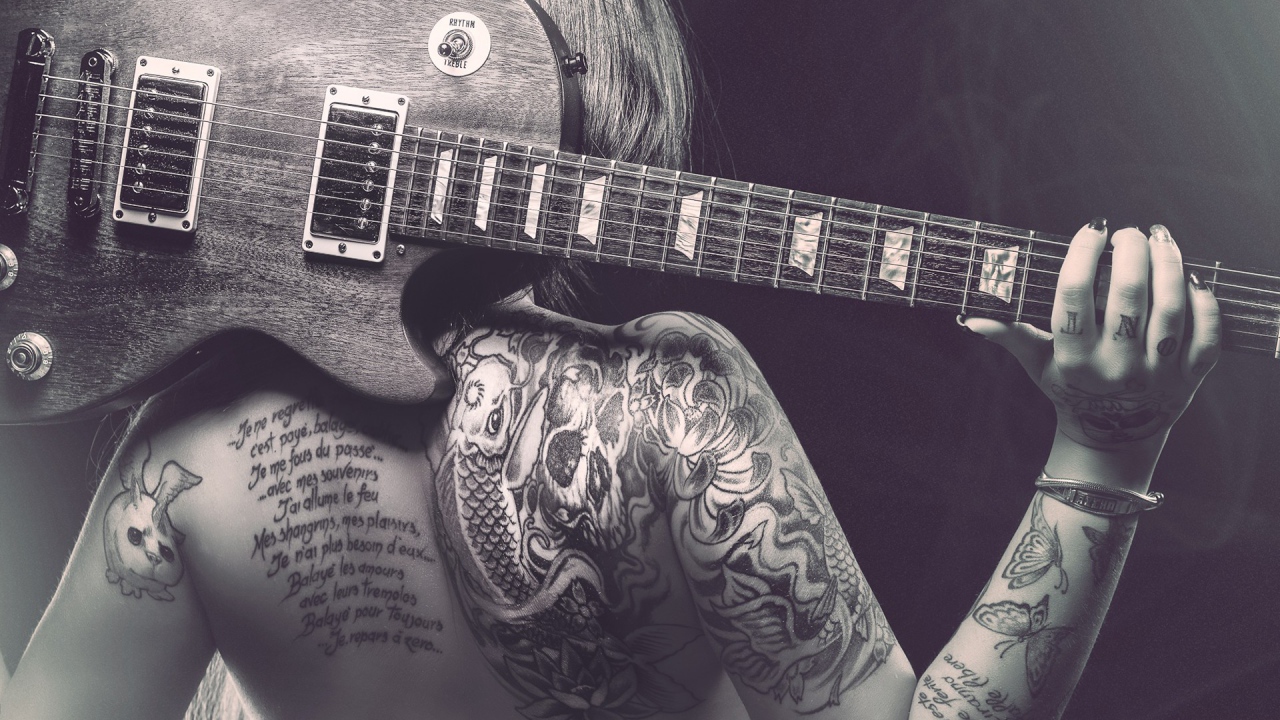 Гитара на спине татуированной девушки