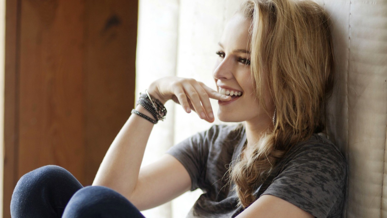 Смеющаяся блондинка приложила палец к губам