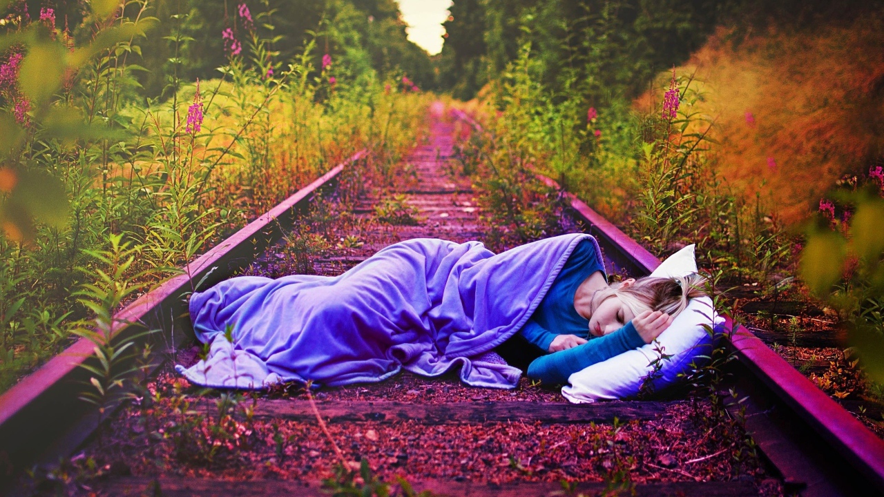 Девушка спит на заброшенных рельсах