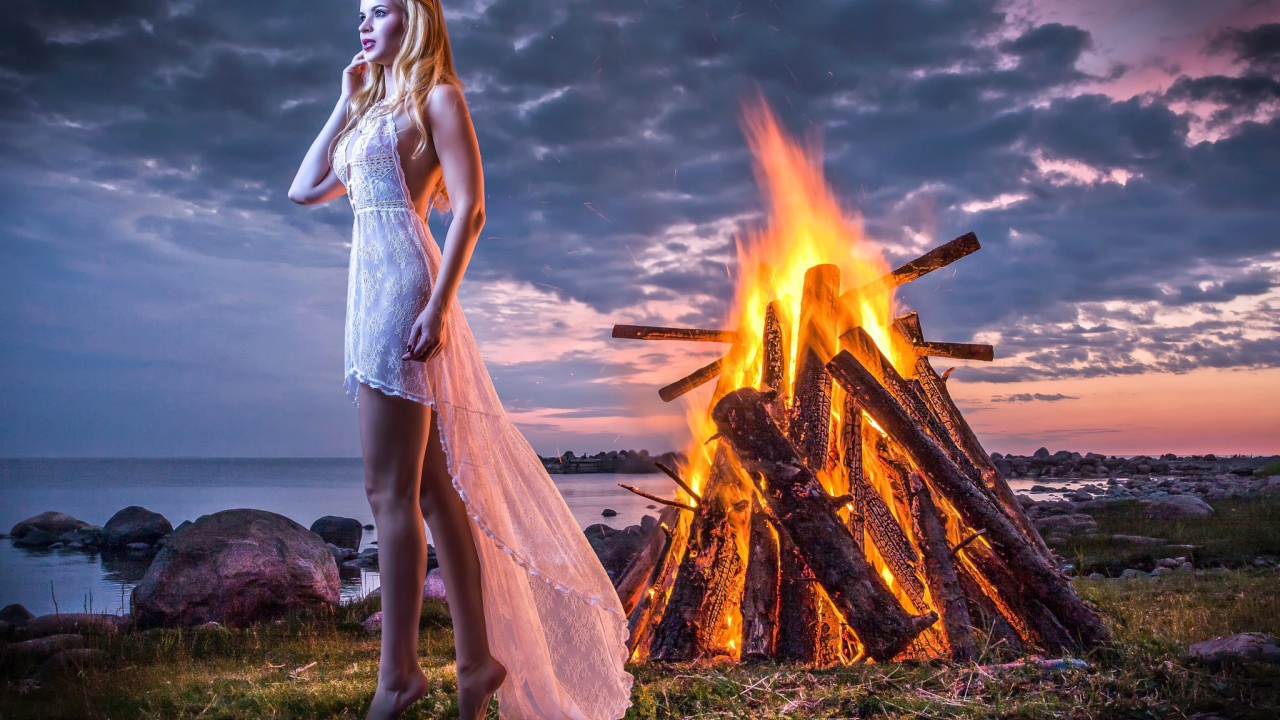Девушка у костра на берегу океана