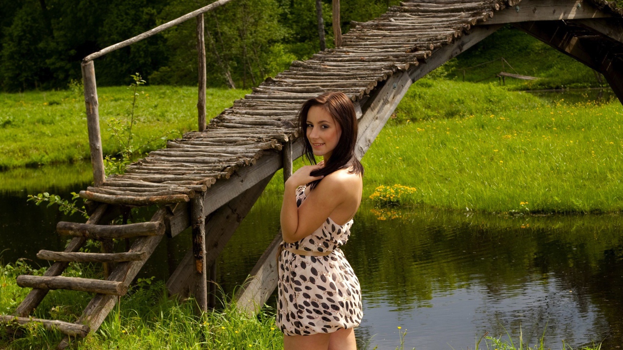 Девушка у деревянного моста через реку