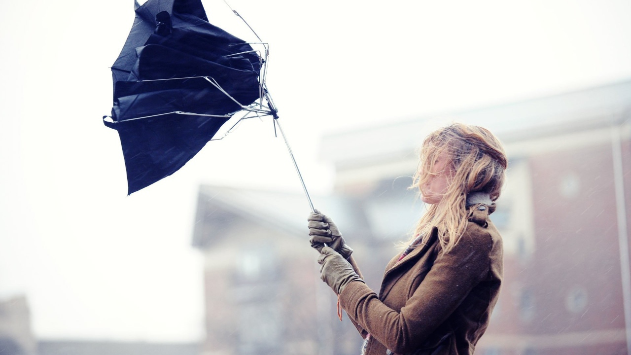 У девушки сломался зонт под напором ветра